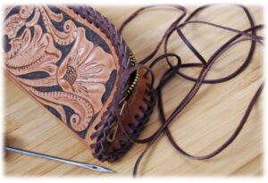 Couture à la main d'une pocchette en cuir avec repoussage